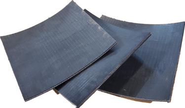 A black leather punch-o-board tool, used for creating holes in leather, showing its curved and textured surface.