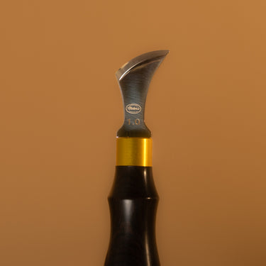 A carving knife for leather projects branded with the Maker's Leather Supply logo, laid out on a solid light brown background.