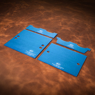 A set of acrylic blue templates for creating a custom `whatever' wallet, laid out on a brown textured leather background.