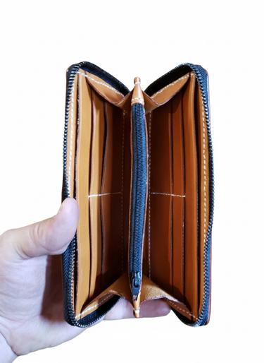 Open brown leather wallet held by a hand on a white background