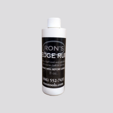 A eight ounce bottle labeled 'RON'S EDGE RUB' with a white cap on a plain background.