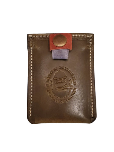A brown leather ribbon wallet with a snap closure and embossed logo on the front.