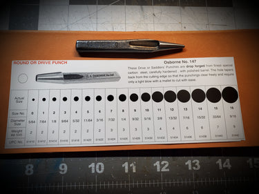 A Saddler's punch tool from C.S. Osborne, placed on a ruler for scale, showing its length and detail.