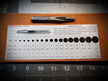 A Saddler's punch tool from C.S. Osborne, placed on a ruler for scale, showing its length and detail.