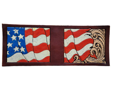A wallet with an embossed pattern featuring the American flag and a decorative design on a brown background.
