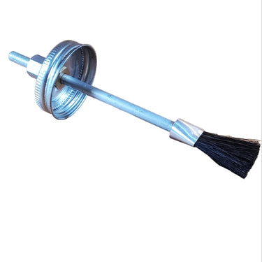 A glue brush with a metal handle lying on a white surface.