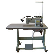 A Cobra Class 20 heavy duty flatbed industrial stitcher sewing machine on a table, primarily gray in color, with various sewing machine parts visible.