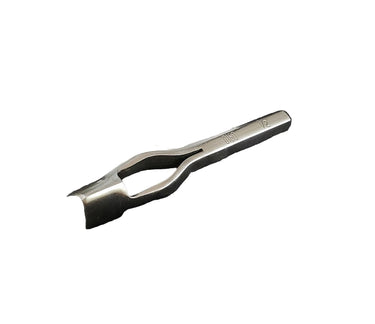 A metal strap end punch tool lying on a white surface.