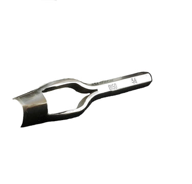 A metal strap end punch tool lying on a white surface.