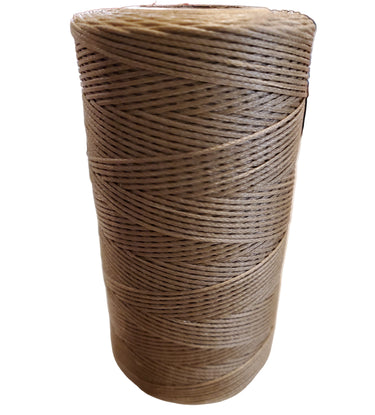 A spool of light brown hand sewing thread placed on a White surface.
