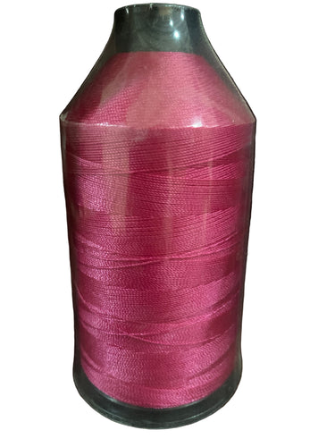 A spool of magenta/hot pink bonded nylon thread placed against a white background.