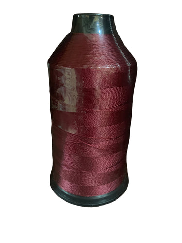 A spool of crimson or maroon bonded nylon thread for sewing machines.