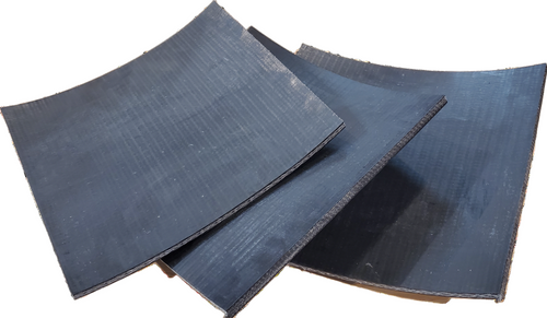 A black leather punch-o-board tool, used for creating holes in leather, showing its curved and textured surface.