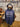 A navy blue hoodie with a maker's leather supply logo, standing on a mannequin in a leather workshop.