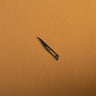 metal scalpel blade on a brown leather background