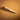 A wooden edge slicker for leather projects laid out on a textured light brown leather background. 