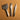 A set of 3 buck-stitching chisels used for stitching with leather projects in the large size. Laid out on a light brown textured leather background. 