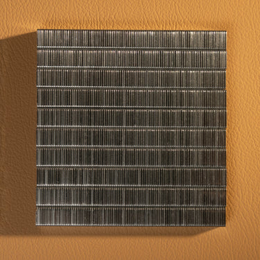 A collection of heavy duty staple refills laid out in a square pattern on a textured brown background. 