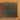 A collection of heavy duty staple refills laid out in a square pattern on a textured brown background. 