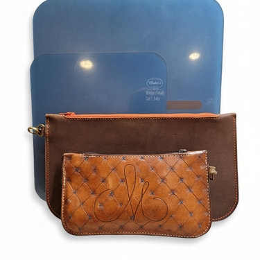 Brown leather pouch with quilted design and gold zipper, behind are two blue acrylic templates for crafting the bags, placed on a white surface.