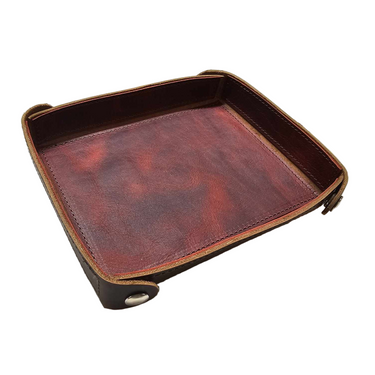 A brown leather tray with metal snaps on the corners, placed on a white background.