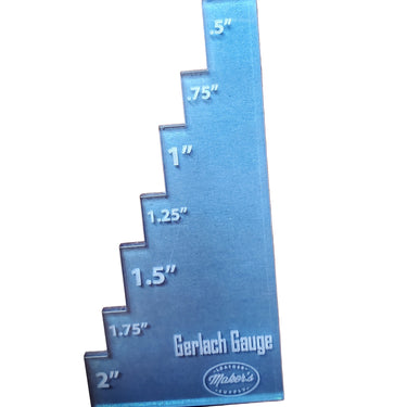 A metal Gerlach Gauge placed on a leather surface, used for adjusting strap cutters in crafting.