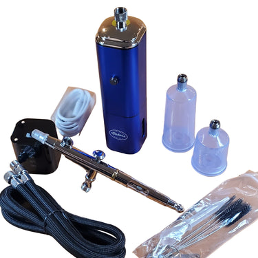 A blue cordless air brush kit with a dual action airbrush gun, a hose, batteries, and other accessories displayed on a white surface.