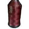 A spool of crimson or maroon bonded nylon thread for sewing machines.